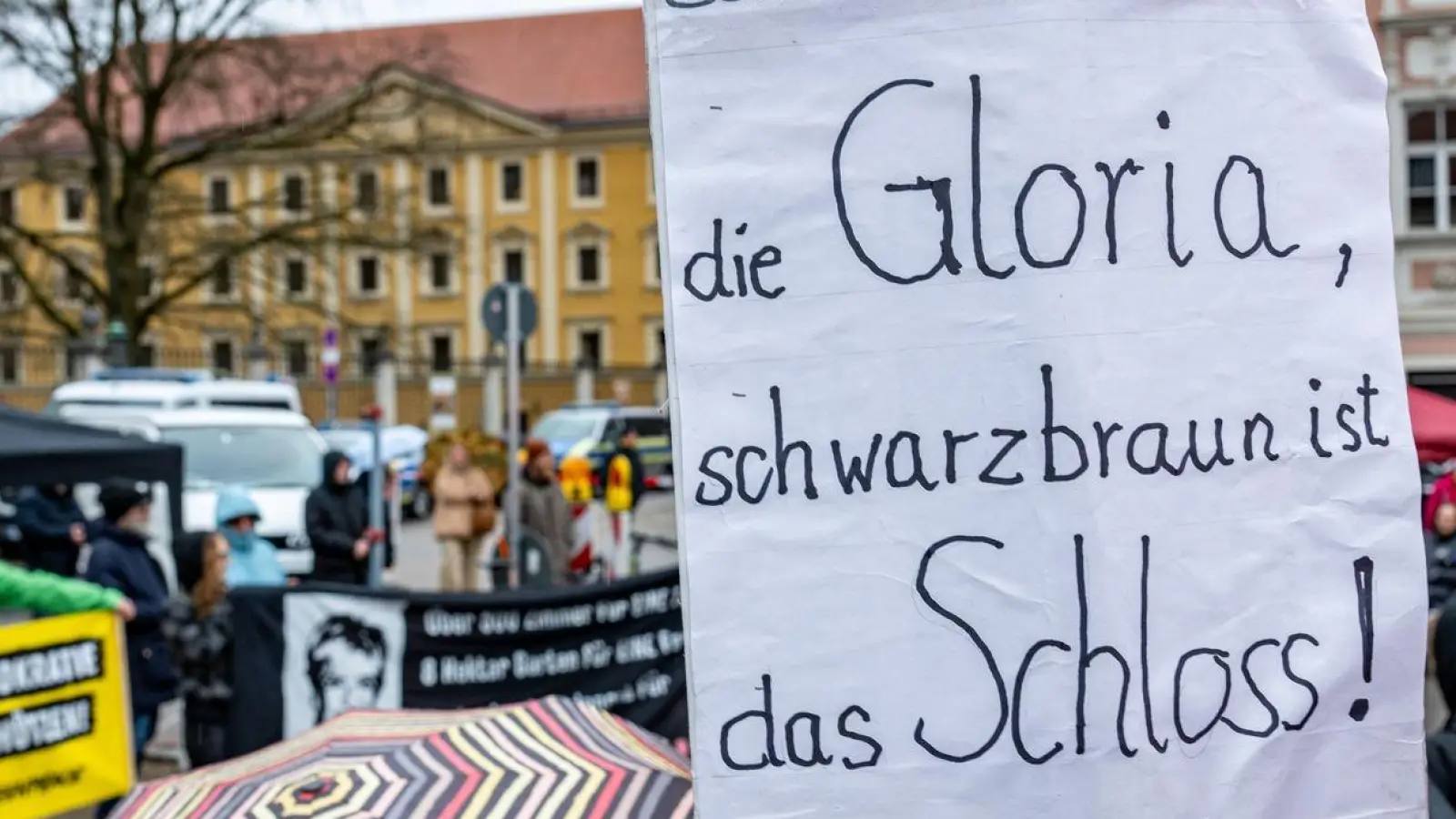 Ein Schild mit der Aufschrift „Schwarzbraun ist die Gloria, schwarzbraun ist das Schloss!“ (Foto: Armin Weigel/dpa)
