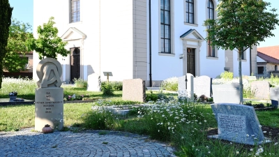 Neu auf dem Friedhof ist auch die Skulptur einer ortsansässigen Künstlerin, die links zu sehen ist. Die Zeichen Omega und Alpha stehen symbolisch für den Anfang und das Ende. (Foto: Luca Paul)