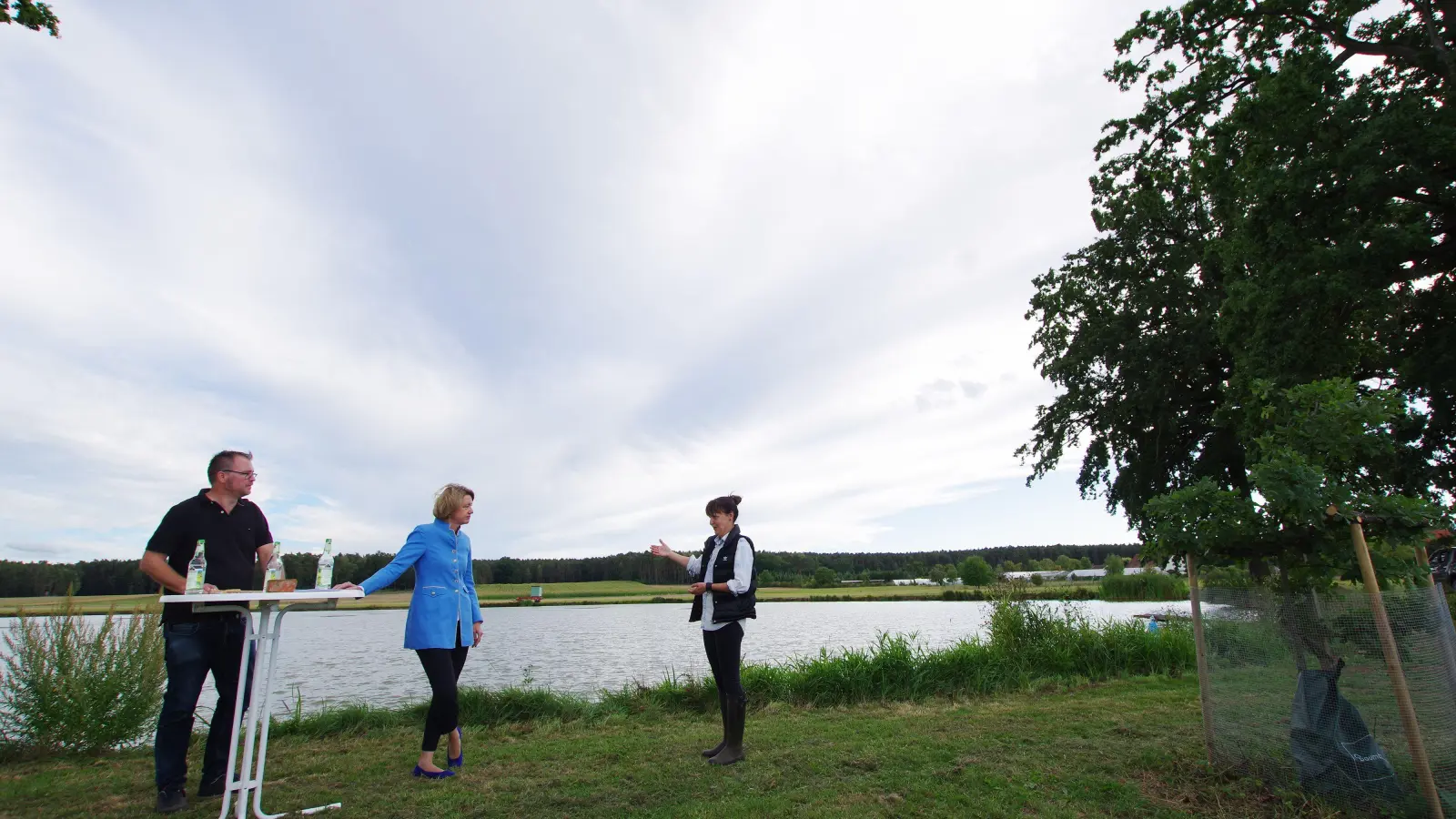 AKU-Bezirksvorsitzender Jens Ostendorf, Anja Weisgerber und Teichwirtin Kerstin Braun vor dem Braunschen Fischweiher in Dürrnfarrnbach (von links). (Foto: Heinz Wraneschitz Redaktionsbüro bildtext.de)