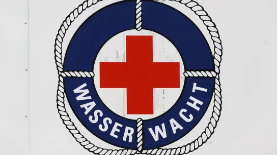 Das Logo der Wasserwacht des DRK an einem Rettungsturm im Ostseebad Warnemünde. Bis September halten die Rettungsschwimmer an bis zu zwölf Türmen Wache. (Foto: Bernd Wüstneck/dpa-Zentralbild/dpa)