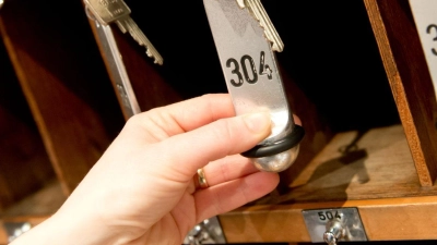 Zimmerschlüssel hängen in einem Hotel an einem Brett an der Hotelrezeption. (Foto: Sven Hoppe/dpa)