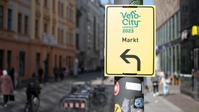 Ein Schild mit dem Logo des Radverkehrskongresses „Velo-city“ markiert einen temporären Radweg im Zentrum von Leipzig. (Foto: Hendrik Schmidt/dpa)