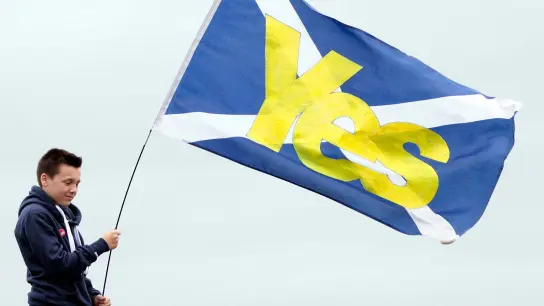 Ein Junge hält eine schottische Flagge mit der Aufschrift „Yes“ in den Händen. (Foto: Graham Stuart/EPA/dpa)