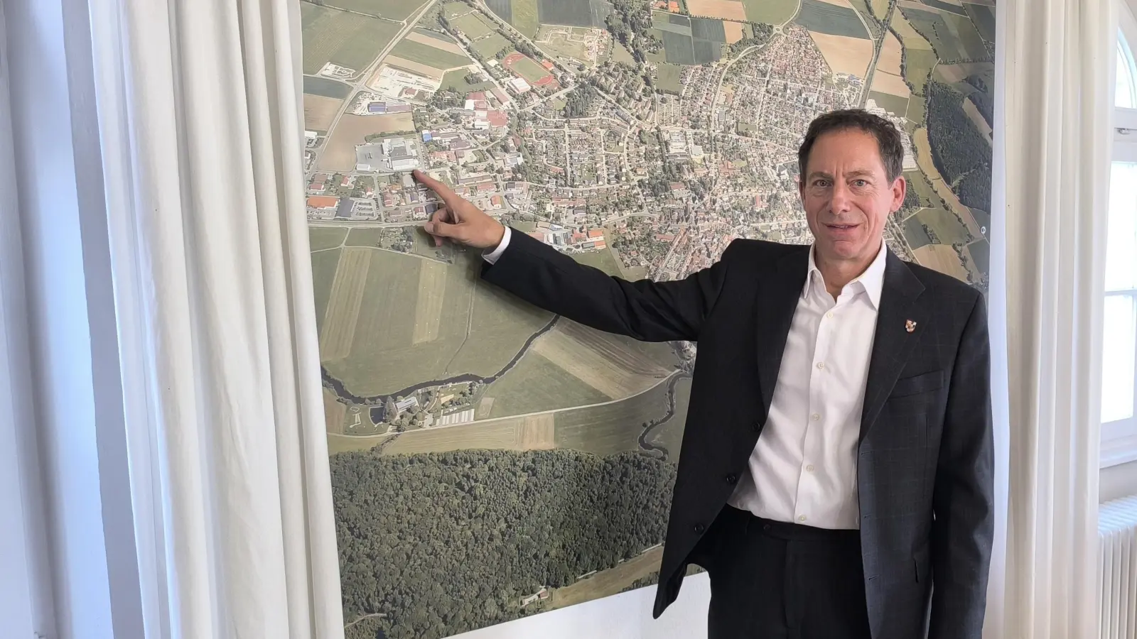 Bürgermeister Stefan Ultsch zeigt auf dem Luftbild von Wassertrüdingen die Position des Geflügelschlachthofs. Das Stadtoberhaupt sieht nach wie vor Chancen, dass die Einrichtung erhalten bleibt.  (Foto: Thomas Schaller)
