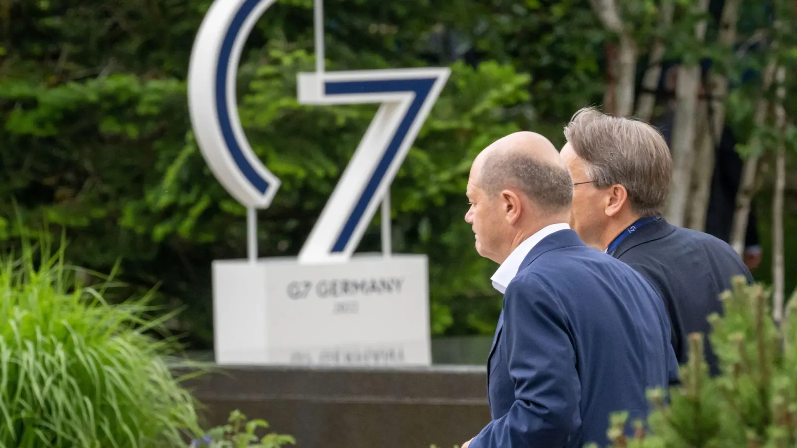 Bundeskanzler Olaf Scholz (SPD, l) geht beim G7-Gipfel nach einer Pause zurück in den Sitzungssaal. (Foto: Peter Kneffel/dpa)