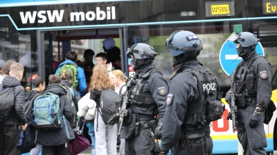 Polizisten führen Schüler in Wuppertal aus dem Gebäude in einen Evakuierungsbus. (Foto: Sascha Thelen/dpa)