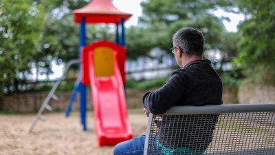 Tobias sitzt allein an einem Spielplatz. Der Vater eines Kindes zieht wegen einer Vaterschaftsanfechtung vor das Bundesverfassungsgericht. (Foto: Jan Woitas/dpa)