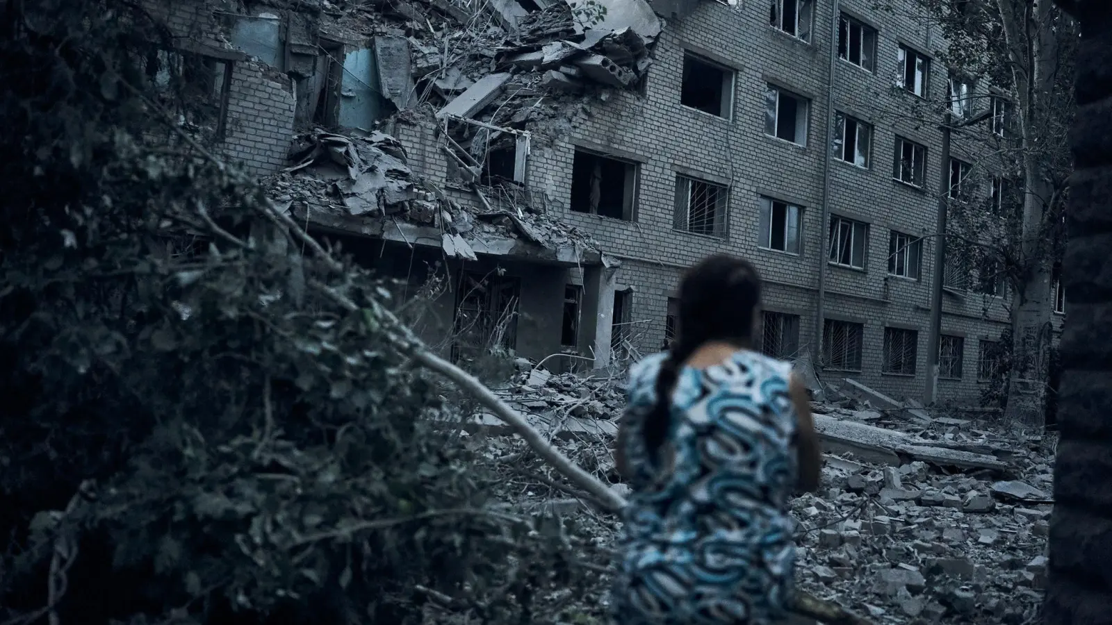 Eine Frau steht inmitten der Trümmer eines Wohnhauses in Mykolajiw, das durch russischen Beschuss zerstört wurde. (Foto: Kostiantyn Liberov/AP/dpa)