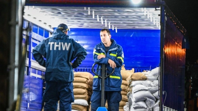 Einsatzkräfte des Technischen Hilfswerks (THW) laden am Logistikzentrum Sandsäcke für Süddeutschland. (Foto: Jason Tschepljakow/dpa)
