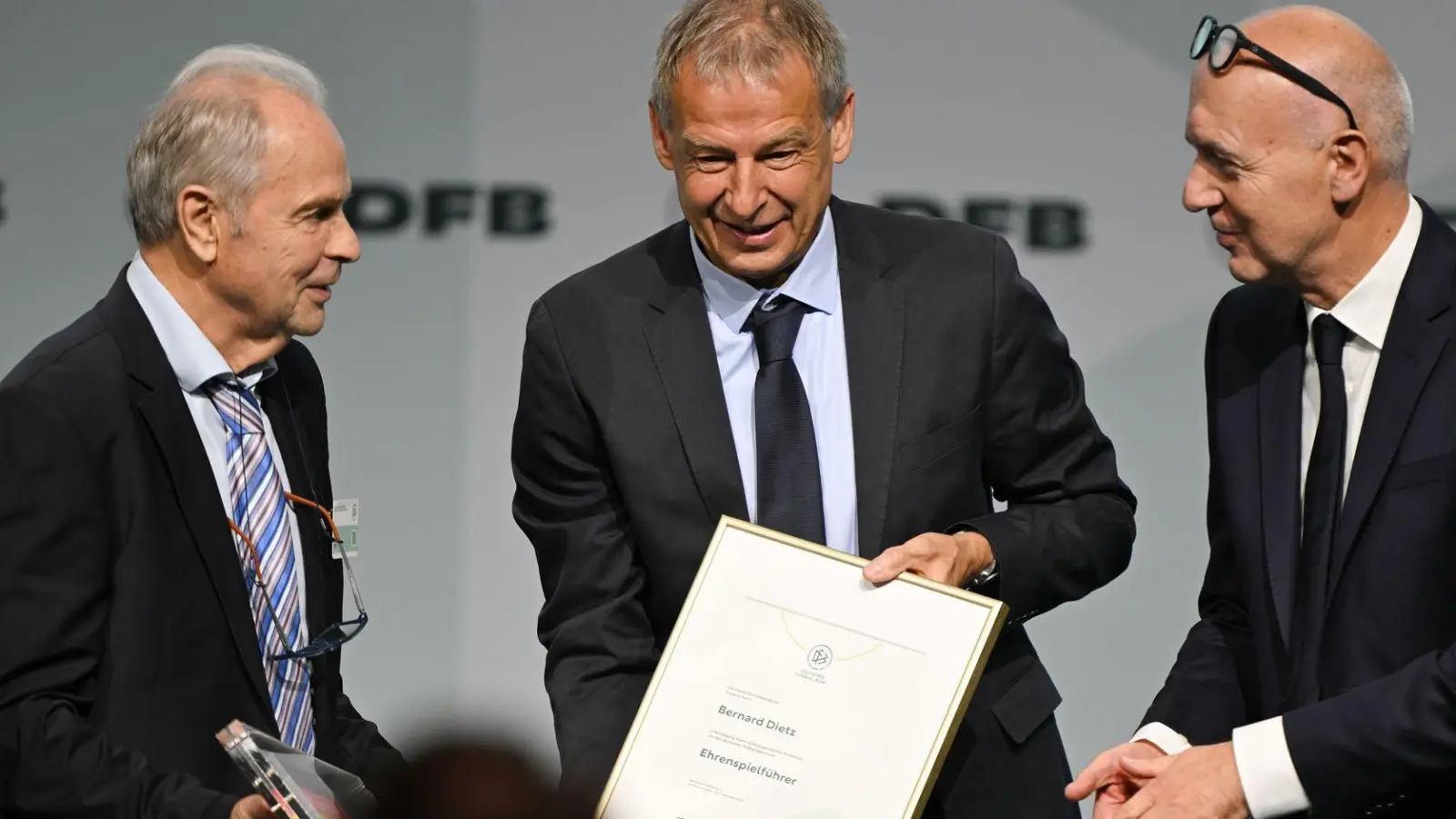 Bernard Dietz (l) wird von Jürgen Klinsmann und DFB-Präsident Bernd Neuendorf für die Ernennung zum Ehrenspielführer gratuliert. (Foto: Arne Dedert/dpa)