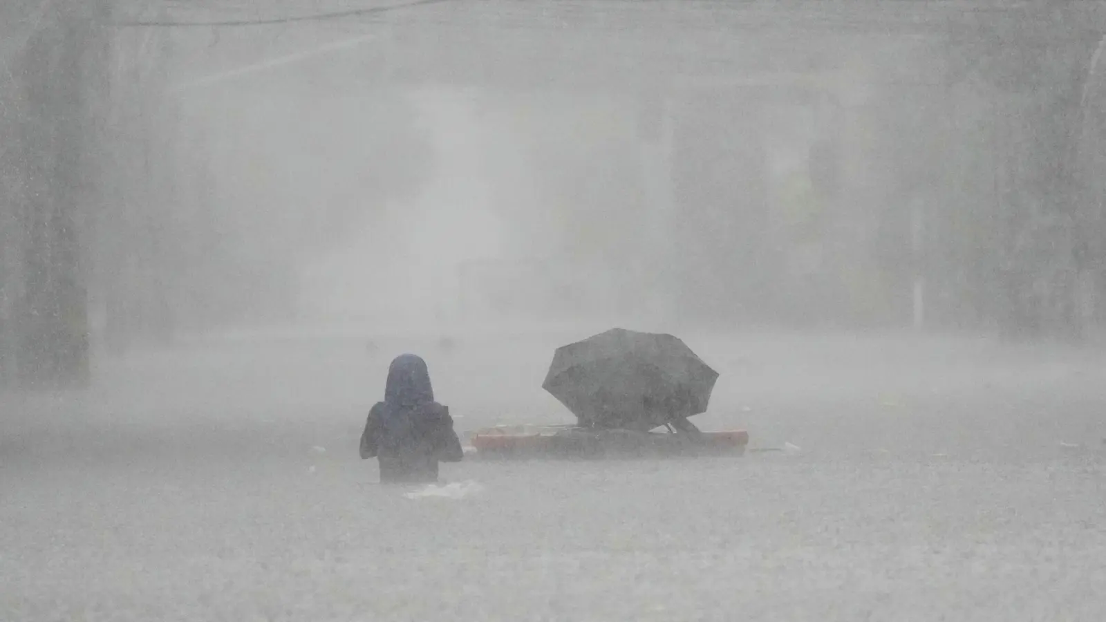 Die Menschen mussten durch brusttiefes Wasser waten. (Foto: Aaron Favila/AP/dpa)