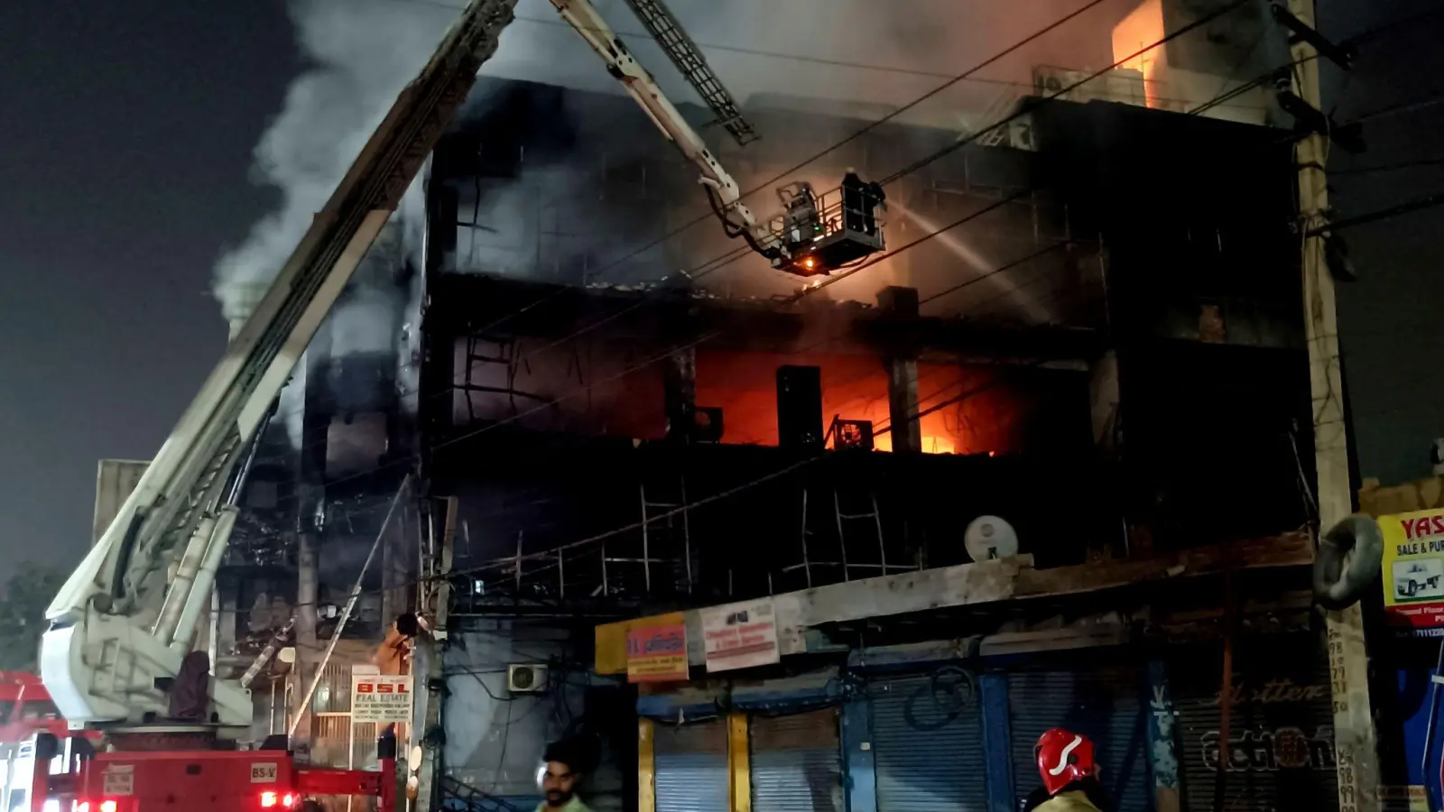 Feuerwehrleute versuchen den Brand zu löschen. (Foto: Dinesh Joshi/AP/dpa)