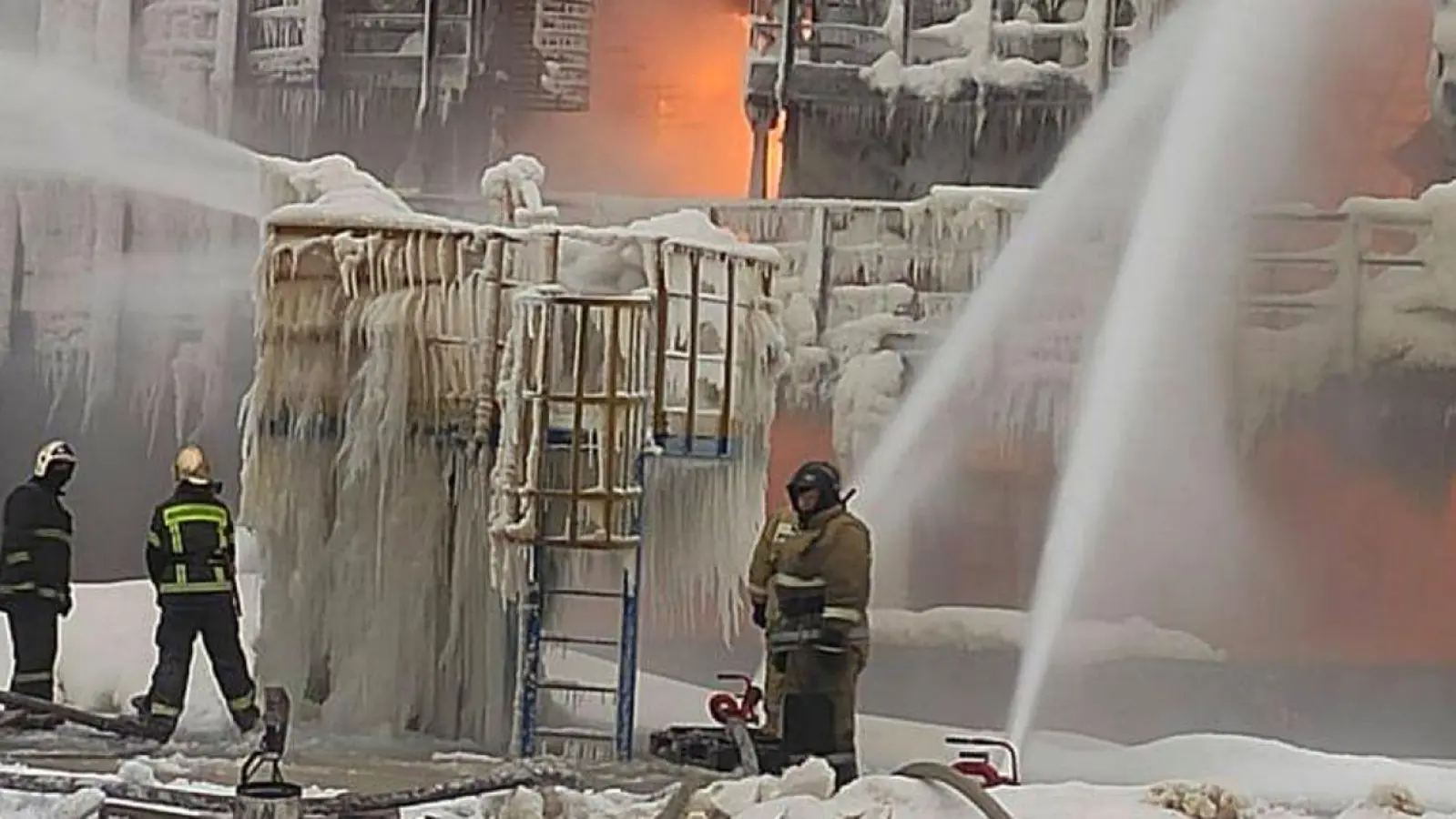 Das auf einem russischen Telegramm-Kanal veröffentlichte Foto soll Feuerwehrleute zeigen, die einen Brand auf dem Gelände des Erdgasproduzenten Novatek im Ostseehafen Ust-Luga löschen. (Foto: Uncredited/Telegram Channel of head of the Kingisepp district administration Yuri Zapalatskiy/AP/dpa)