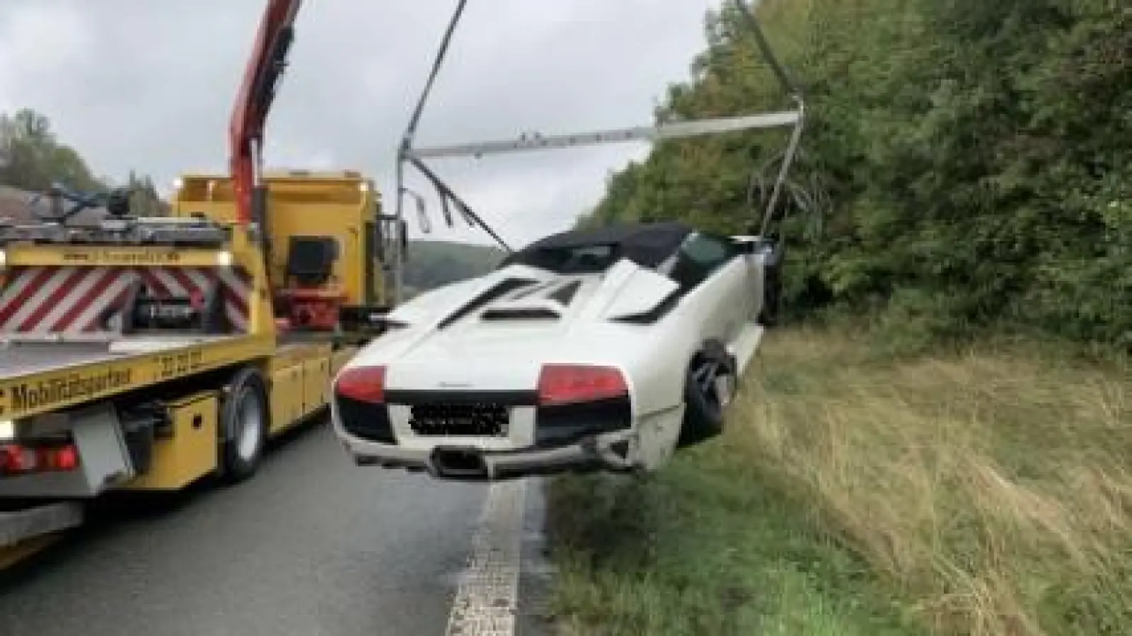 Teures Wrack: Etwa 150.000 Euro hängen hier am Haken des Abschleppkranes.  (Foto: Polizei)