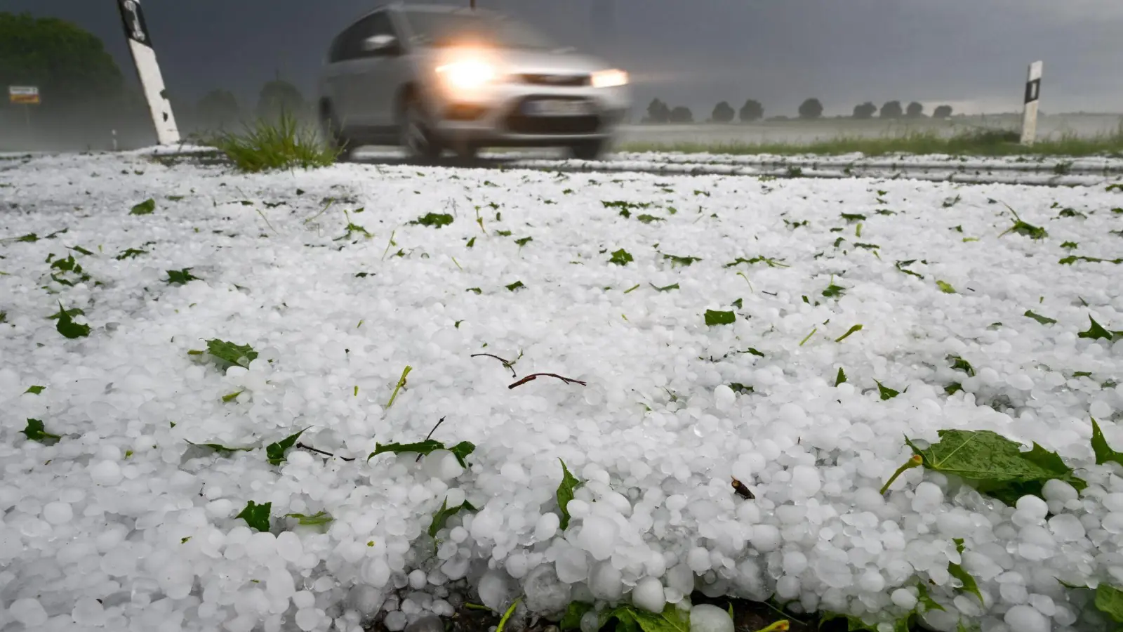 Hagel liegt auf der Straße. Ein Unwetter hatte sich zuvor in der Region um Laupheim mit Blitz und Hagel entladen. (Foto: Felix Kästle/dpa)