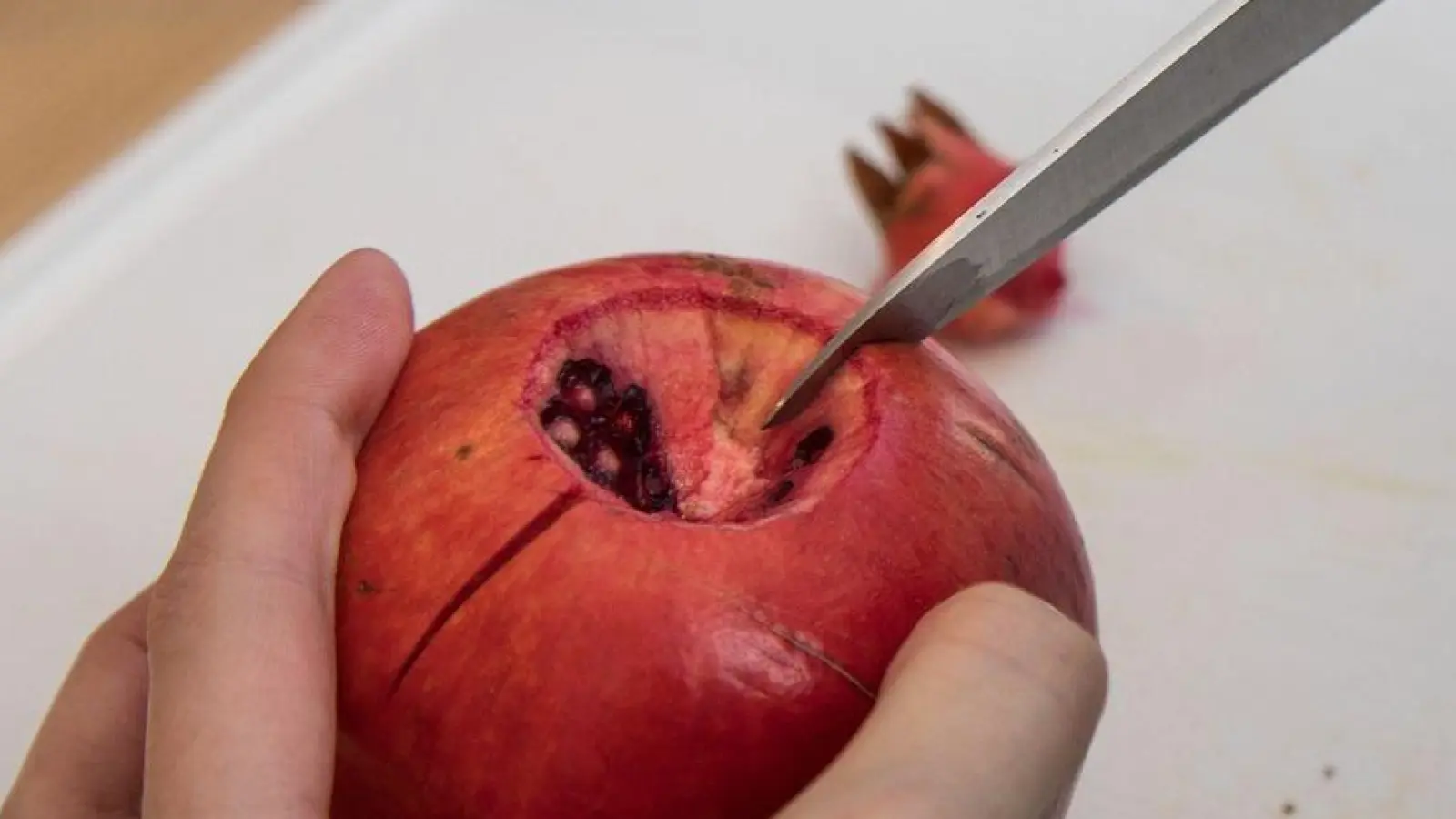 Ran an den Granatapfel: Erst kommt das Messer, dann das Wasserbad. (Foto: Christin Klose/dpa-tmn)