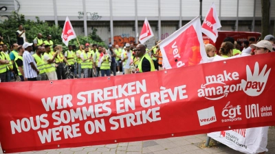 Beschäftigte von Amazon bei einer Demonstration unter dem Titel „Make Amazon Pay! Für gute und gesunde Arbeit bei Amazon!“ vor dem Amazon-Verteilzentrum in Hamburg-Veddel. (Foto: Christian Charisius/dpa)