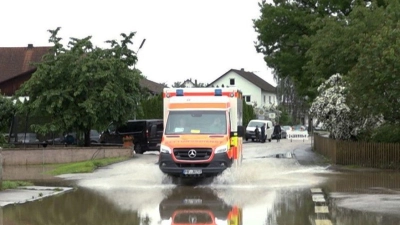 Ein Krankenwagen fährt über eine überschwemmte Straße in Pfaffenhofen an der Ilm. (Foto: -/tv7news/dpa)