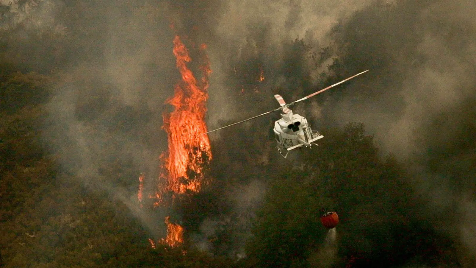 Ein Löschhubschrauber wirft Wasser über einem Feuer in der spanischen Provinz Ourense ab. (Foto: Adrián Irago/EUROPA PRESS/dpa)