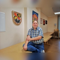 Mit seiner Rolle als ehrenamtlicher Bürgermeister von Buch am Wald kommt Hartmut Buckel gut klar. Das Foto zeigt ihn im Sitzungssaal neben dem Gemeindewappen. (Foto: Jürgen Binder)