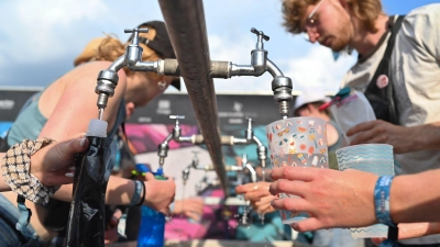 Besucher füllen beim Hurricane Festival ihre Becher und Trinkflaschen mit Wasser auf. In Deutschland steigen die Temperaturen - und die Ozon-Werte. (Foto: Lars Penning/dpa)