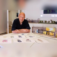 Bringt „Der Diener zweier Herren” im Kreuzgang auf die Bühne: der Regisseur Achim Conrad. Vor ihm liegen Kostümentwürfe, die Heike Engelbert für die Komödie gezeichnet hat. Neben ihm steht ein Bühnenbildmodell von Werner Brenner. (Foto: Thomas Wirth)