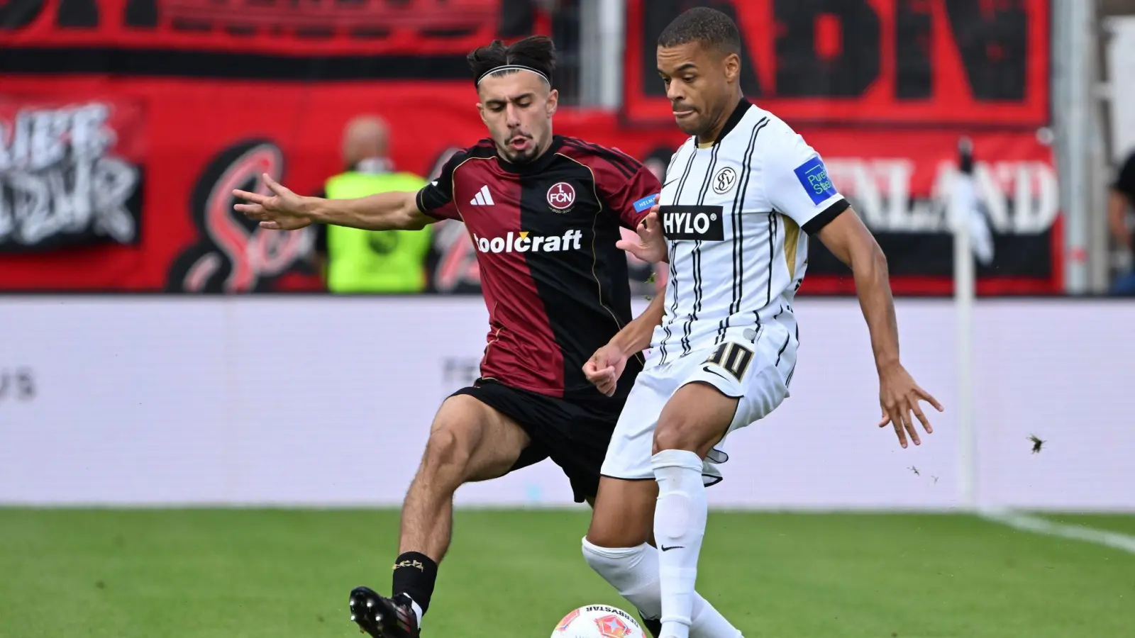 Die SV Elversberg um Jan Gyamerah (r) und der 1. FC Nürnberg um Berkay Yılmaz lieferten sich einen umkämpften Zweitliga-Auftakt. (Foto: Harald Tittel/dpa)