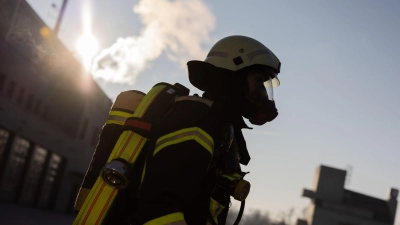 Ein Feuerwehrmann in Atemschutzausrüstung steht an einem Einsatzort. (Foto: Rolf Vennenbernd/dpa/Symbolbild)