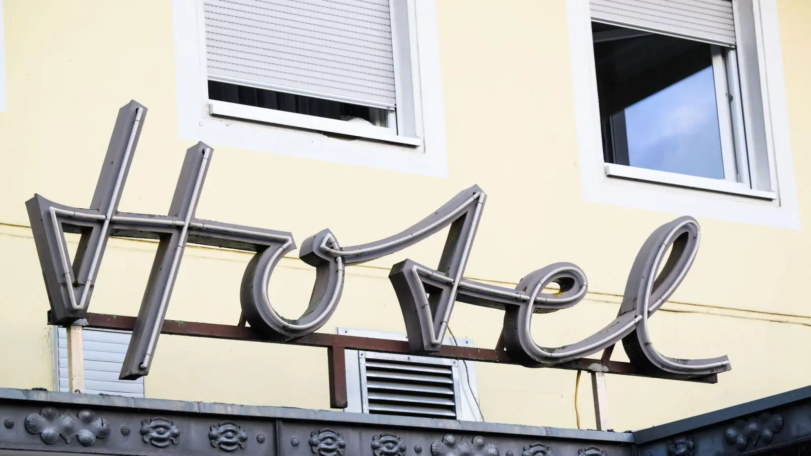 Ein Schriftzug hängt am Eingang eines Hotels. (Foto: Julian Stratenschulte/dpa/Symbolbild)