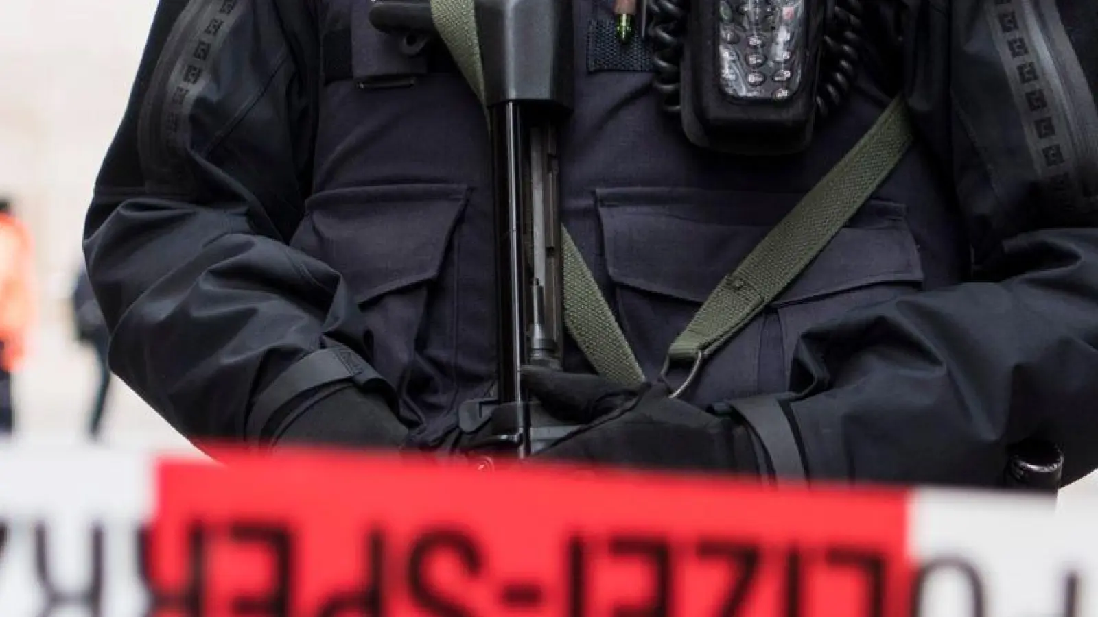Ein schwer bewaffneter Polizist hinter einem Absperrband in der Züricher Innenstadt (Symbolbild). (Foto: Ennio Leanza/KEYSTONE/dpa)