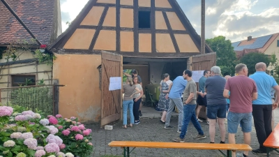 Vor dem Beginn der eigentlichen Versammlung standen die Teilnehmenden schon in Grüppchen zusammen und betrachteten die Pläne, die an die geöffneten Türen des Hirtenhäuschens gepinnt worden waren. (Foto: Ulli Ganter)