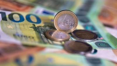 Geldscheine mit dem Wert von 100 und 50 Euro und Münzen liegen auf einem Tisch. (Foto: Monika Skolimowska/dpa)