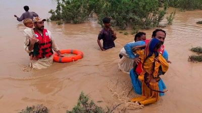 Rettungskräfte helfen Dorfbewohnern bei der Evakuierung aus einem durch starke Regenfälle überfluteten Gebiet. Wegen Rekordfluten müssen in der pakistanischen Provinz Belutschistan derzeit mindestens 50.000 Familien aus ihren Dörfern in Sicherheit gebracht werden. (Foto: Hamdan Khan/AP/dpa)