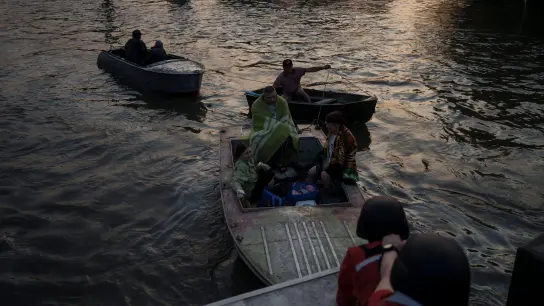 Rettungskräfte versuchen, Boote mit Bewohnern abzuschleppen. (Foto: Felipe Dana/AP/dpa)