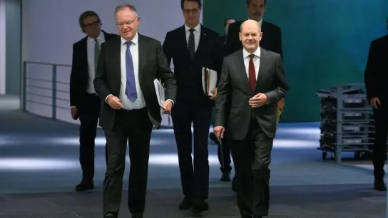 Bundeskanzler Olaf Scholz, dier niedersächsische Ministerpräsident Stephan Weil und Hendrik Wüst, Ministerpräsident von Nordrhein-Westfalen, auf dem Weg zu einer Pressekonferenz. (Foto: Bernd von Jutrczenka/dpa)