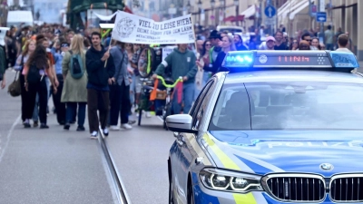 Ein Polizeiauto fährt vor den Teilnehmenden der Demonstration „Krachparade“ durch die Maximilianstraße. (Foto: Felix Hörhager/dpa)