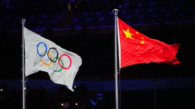 Die Olympische Fahne und die chinesische Flagge wehen im Olympiastadion von Peking. (Foto: Michael Kappeler/dpa)