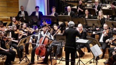 Begeisterten ihr Publikum beim Neujahrskonzert der VR-Bank Mittelfranken Mitte: die Nürnberger Symphoniker unter der Leitung von Jonathan Darlington und der Cellist Bryan Cheng. (Foto: Margit Schwandt)