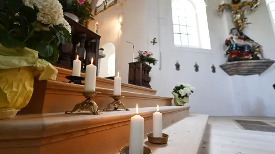 In der Wallfahrtskirche St. Anton in Garmisch-Partenkirchen stehen fünf Kerzen zum Gedenken an die Todesopfer. (Foto: Angelika Warmuth/dpa)