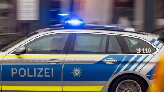 Ein Fahrzeug der bayerischen Polizei fährt mit Blaulicht durch die Innenstadt. (Foto: Peter Kneffel/dpa/Symbolbild)