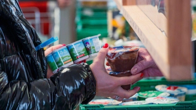 Eine Kundin (l) der Tafel Coburg bekommt Joghurt und Pudding. Der Landesverband Tafel Bayern e. V. besteht aus insgesamt 171 Mitgliedstafeln. (Archivbild) (Foto: Daniel Vogl/dpa)