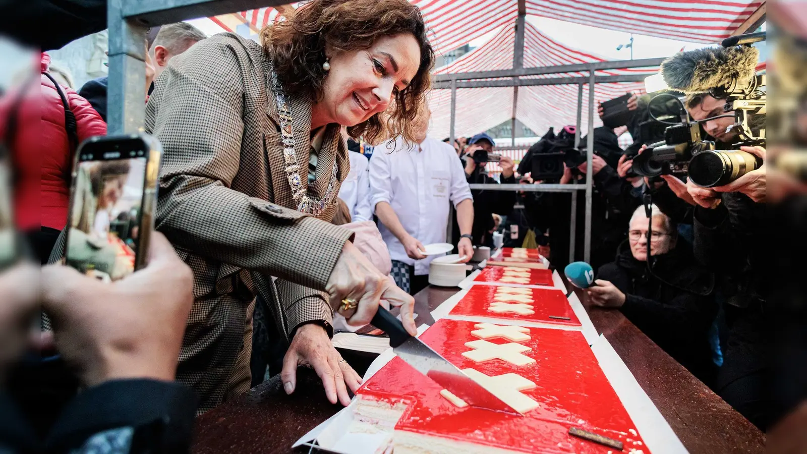Amsterdams Bürgermeisterin Femke Halsema schneidet die lange Torte an.  (Foto: Ramon Van Flymen/ANP/dpa)