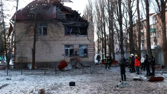 Rettungskräfte stehen in der Nähe eines beschädigten Gebäudes in Kiew. (Foto: -/Ukrinform/dpa)