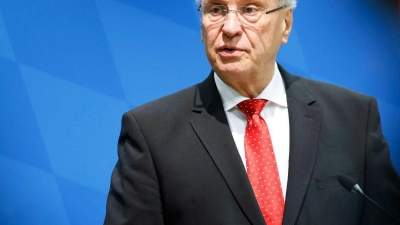 Bayerns Innenminister Joachim Herrmann (r, CSU) spricht in einer Pressekonferenz. (Foto: Daniel Löb/dpa)