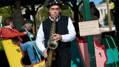 Gerne sorgt Toni Schleifer am Saxofon auch selbst für die passende Musik an seinem historischen Fahrgeschäft. (Foto: Sven Hoppe/dpa)