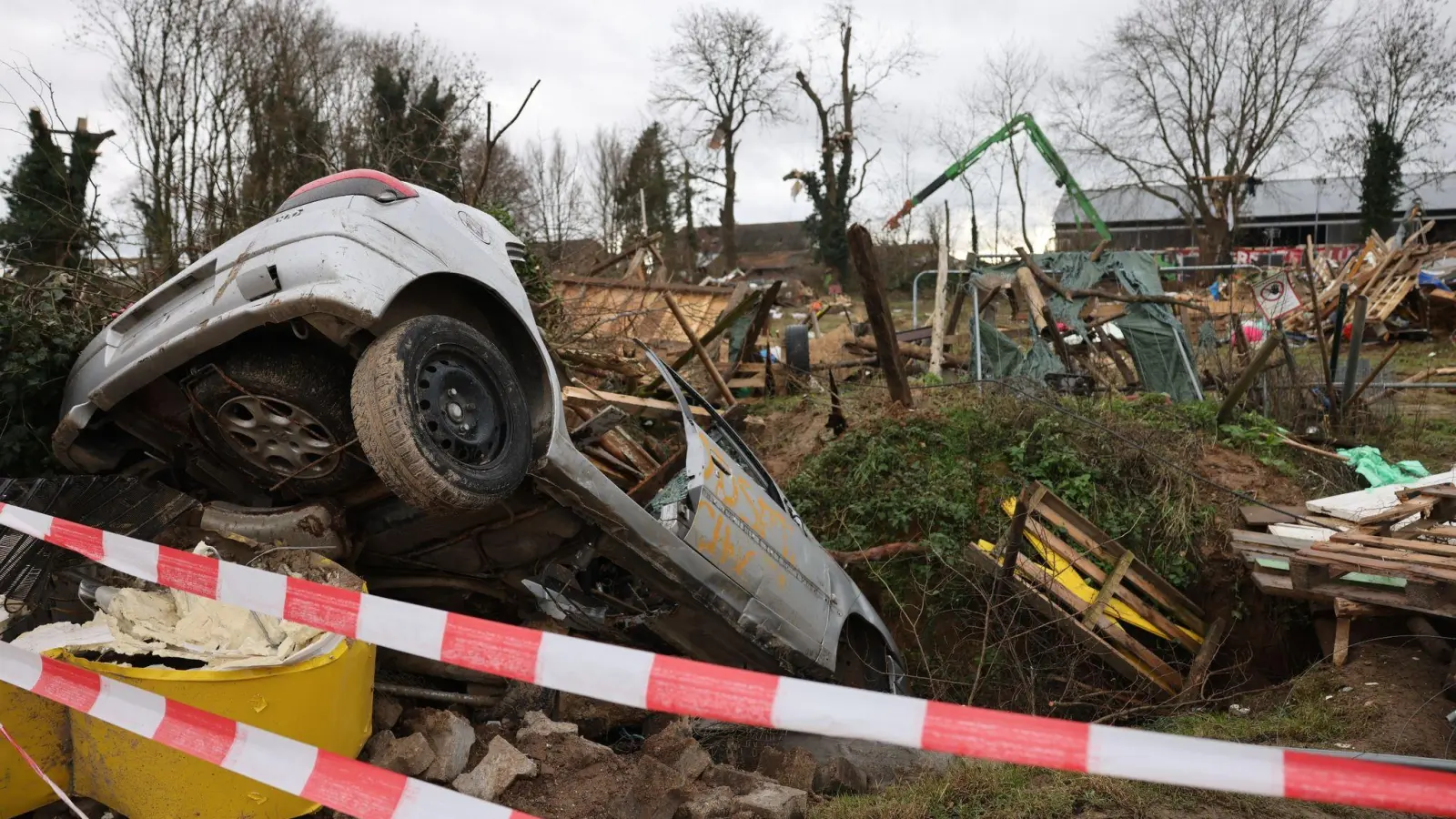 Trümmer der Holzhütten und ein Schrottauto liegen nach der Räumung in Lützerath herum. (Foto: Oliver Berg/dpa)