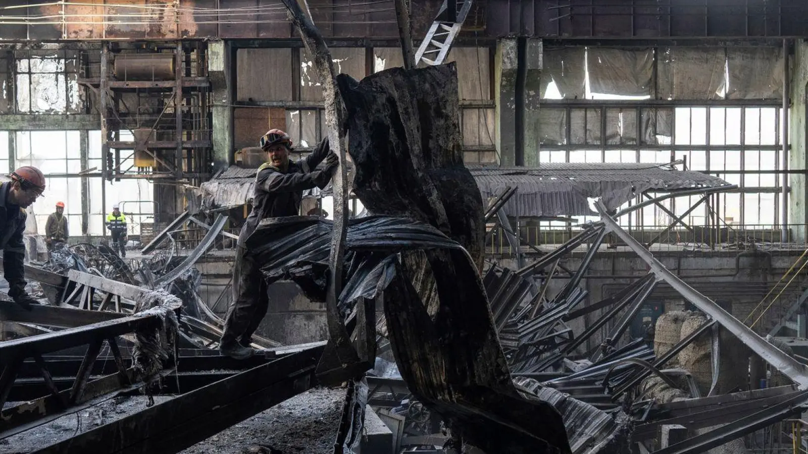 Arbeiter räumen die Trümmer nach einem russischen Raketenangriff auf ein DTEK-Kraftwerk in der Ukraine auf. (Foto: Evgeniy Maloletka/AP/dpa)