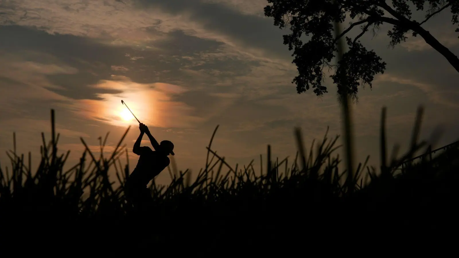 Golf kann so romantisch sein: Adam Schenk schlägt am 10. Loch im Gegenlicht der Sonne während der zweiten Runde des US Open Golfturniers in Oakmont im US-Staat Pennsylvania ab. (Foto: Carolyn Kaster/AP/dpa)