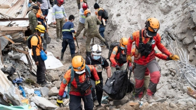 Rettungskräfte tragen ein Opfer aus dem von einem Erdrutsch betroffenen Dorf Masara. Die Zahl der Toten stieg auf 37. (Foto: Uncredited/AP/dpa)