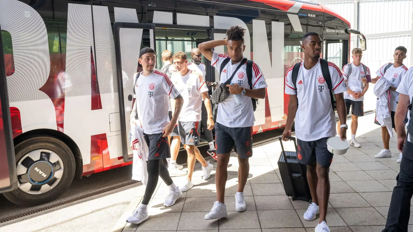 Die Spieler vom FC Bayern München gehen auf dem Münchner Flughafen zum Abflugterminal. (Foto: Peter Kneffel/dpa)